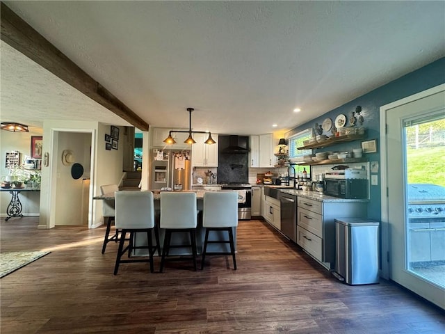 1060 Sugar Run Rd, Nottingham, PA 15367 - kitchen featuring appliances with stainless steel finishes, white cabinets, a breakfast bar, a center island, and wall chimney range hood