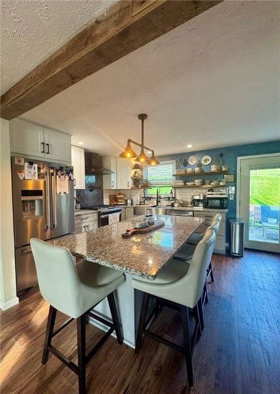 1060 Sugar Run Rd, Nottingham, PA 15367 - kitchen with appliances with stainless steel finishes, wall chimney exhaust hood, a textured ceiling, white cabinets, and healthy amount of natural light