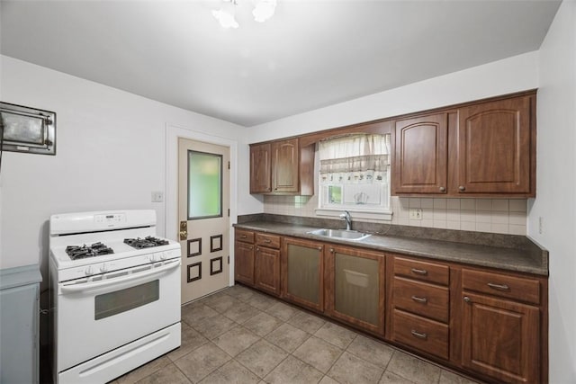 191 Clearview, West View, PA 15229 - kitchen with white gas stove, a sink, dark countertops, backsplash, and light tile patterned floors