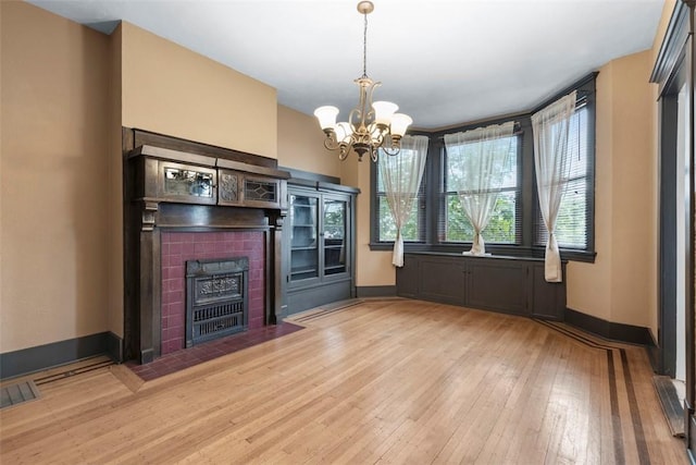 2938 Voelkel Ave, Dormont, PA 15216 - unfurnished living room featuring light wood finished floors, baseboards, a chandelier, and a fireplace with flush hearth