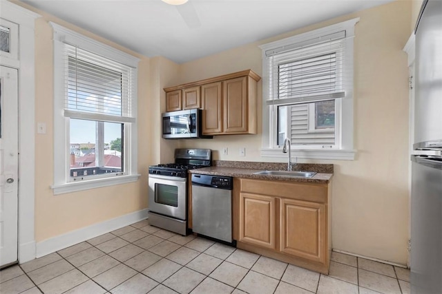 2938 Voelkel Ave, Dormont, PA 15216 - kitchen with stainless steel appliances, a sink, dark countertops, light tile patterned floors, and baseboards