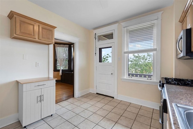 2938 Voelkel Ave, Dormont, PA 15216 - kitchen featuring stainless steel appliances, light tile patterned floors, baseboards, light countertops, and a sink