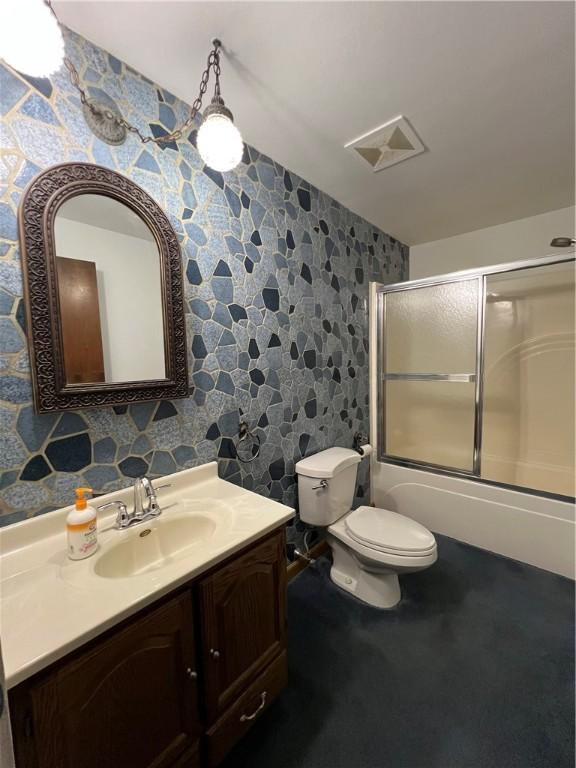 4130 James Dr, Lower Burrell, PA 15068 - bathroom featuring wallpapered walls, vanity, shower / bath combination with glass door, and toilet