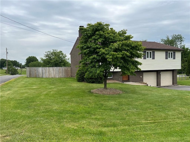 4130 James Dr, Lower Burrell, PA 15068 - view of front facade featuring asphalt driveway, an attached garage, brick siding, and a chimney