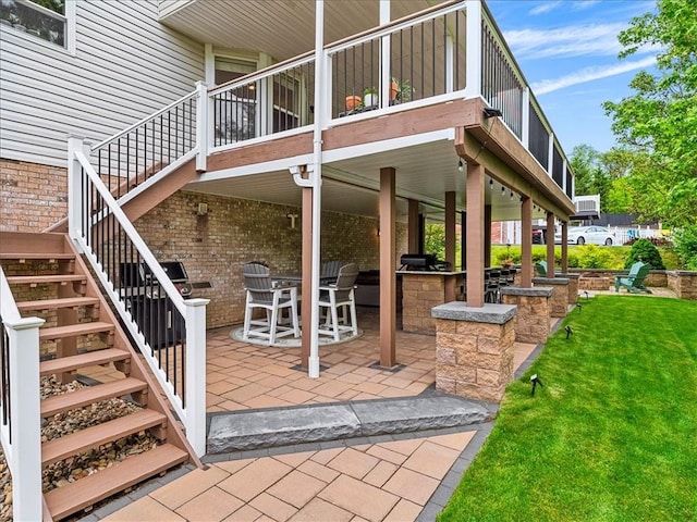 13 Westchester Ct, Robinson Twp Nwa, PA 15136 - view of exterior entry featuring a patio area, a lawn, brick siding, and a wooden deck