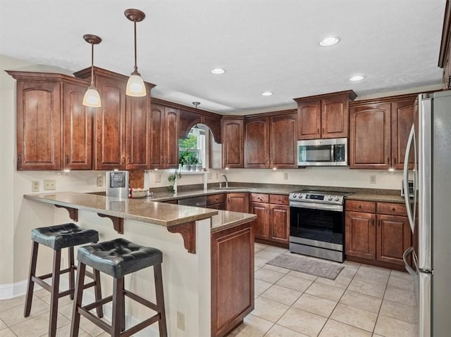 13 Westchester Ct, Robinson Twp Nwa, PA 15136 - kitchen with stainless steel appliances, a peninsula, recessed lighting, light tile patterned flooring, and a kitchen bar