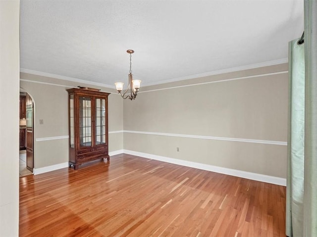 13 Westchester Ct, Robinson Twp Nwa, PA 15136 - spare room featuring arched walkways, wood finished floors, a chandelier, baseboards, and ornamental molding