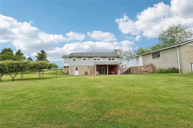 1509 Edmon Rd, Kiskiminetas Twp, PA 15618 - rear view of property featuring stairs, a lawn, a chimney, and a deck