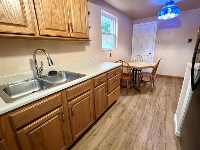 3329 Recker Dr, Baldwin Boro, PA 15227 - kitchen featuring a sink, light wood-style flooring, brown cabinetry, light countertops, and baseboards