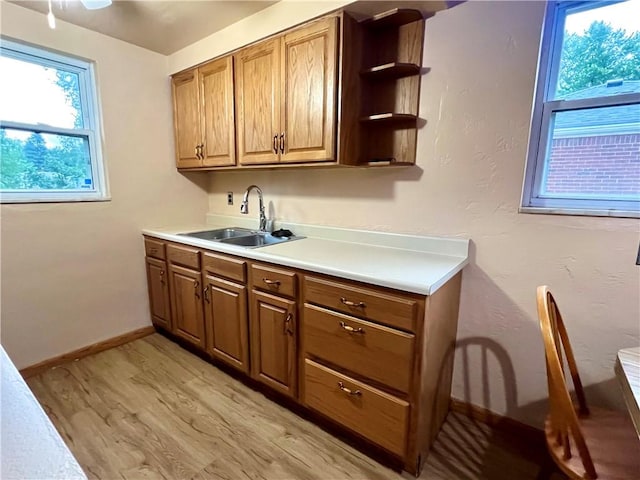 3329 Recker Dr, Baldwin Boro, PA 15227 - kitchen featuring a sink, light wood-type flooring, light countertops, open shelves, and brown cabinets