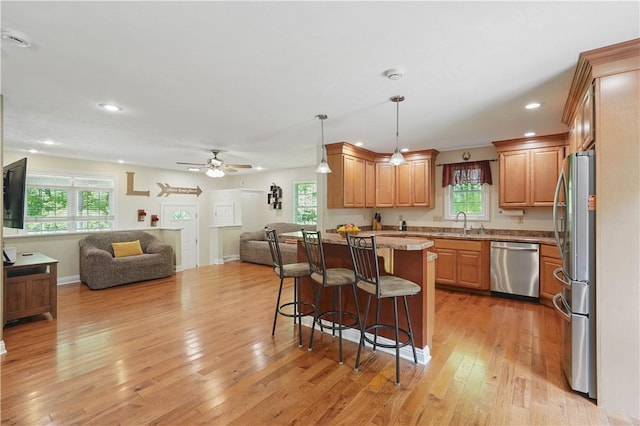 1125 Annisville Rd, Washington Twp But, PA 16050 - kitchen with appliances with stainless steel finishes, open floor plan, a breakfast bar area, light wood-style flooring, and ceiling fan