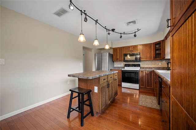 174 Hague Ln, South Union Twp, PA 15401 - kitchen featuring electric range, black microwave, freestanding refrigerator, brown cabinets, and a sink