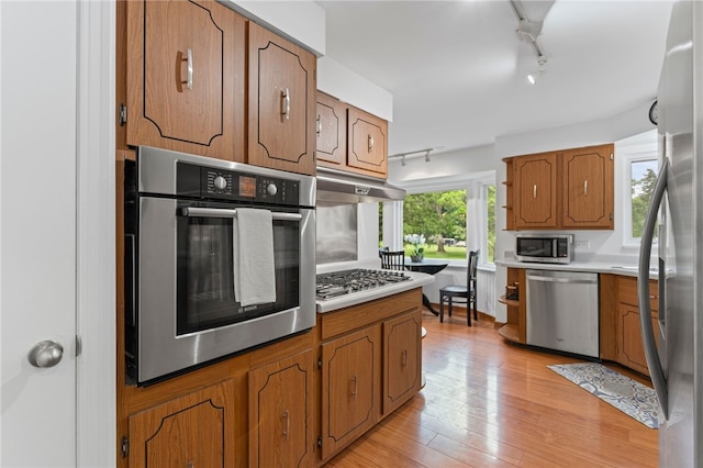 1527 W Ingomar Rd, Franklin Park, PA 15237 - kitchen with stainless steel appliances, track lighting, under cabinet range hood, brown cabinetry, and light countertops