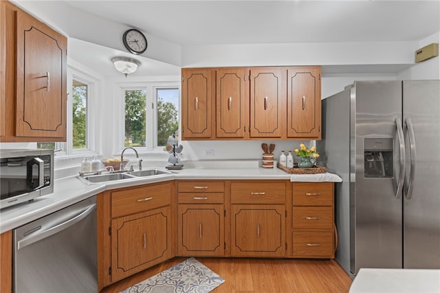 1527 W Ingomar Rd, Franklin Park, PA 15237 - kitchen with appliances with stainless steel finishes, a sink, light countertops, light wood-type flooring, and brown cabinets