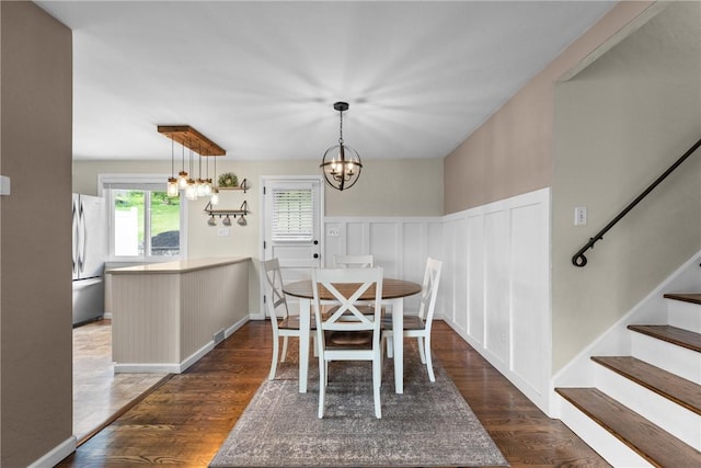 6032 Dalmation Dr, Bethel Park, PA 15102 - dining area featuring a chandelier, wood finished floors, stairway, and a wainscoted wall