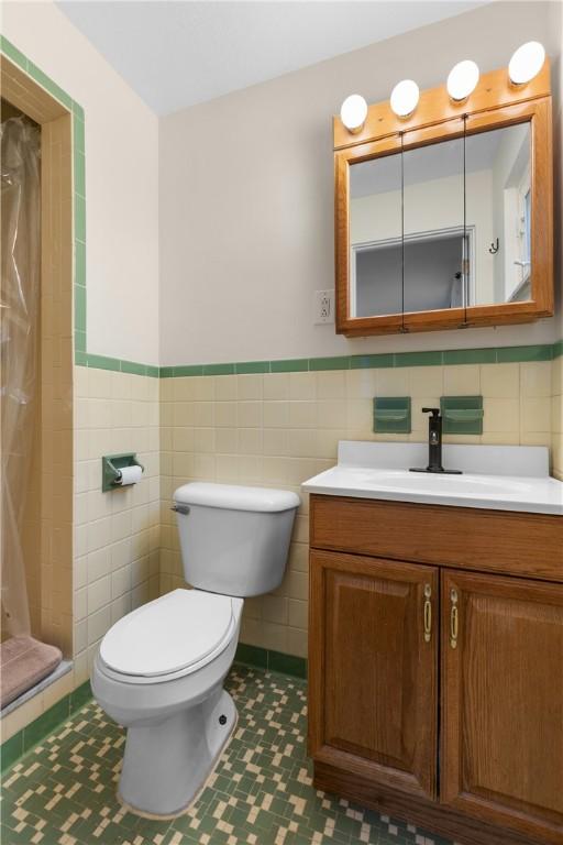 6032 Dalmation Dr, Bethel Park, PA 15102 - full bath with tile walls, vanity, toilet, curtained shower, and tile patterned floors