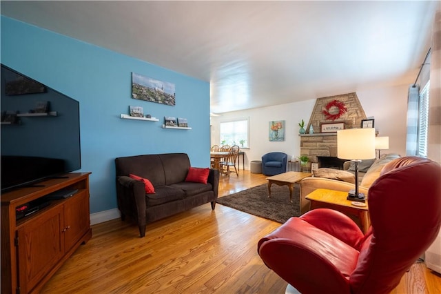 127 Burns Ave, Chippewa Twp, PA 15010 - living area with a stone fireplace, light wood-type flooring, and baseboards