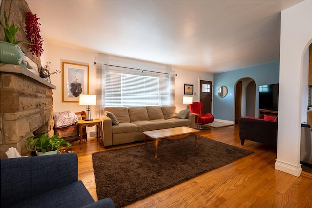127 Burns Ave, Chippewa Twp, PA 15010 - living room with arched walkways, a stone fireplace, and wood finished floors