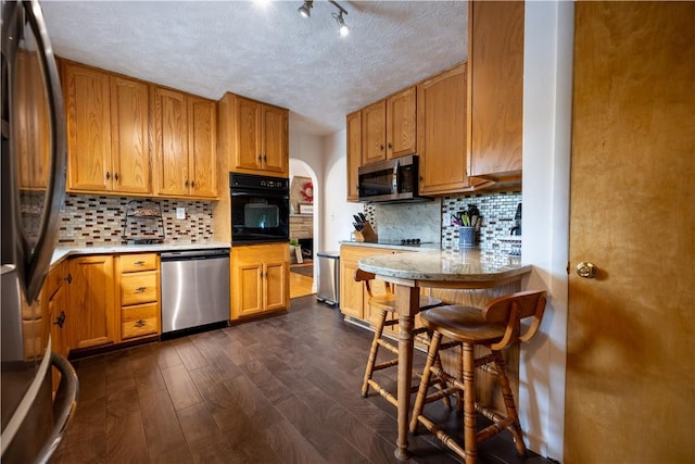 127 Burns Ave, Chippewa Twp, PA 15010 - kitchen with black appliances, tasteful backsplash, dark wood-style floors, a textured ceiling, and brown cabinets