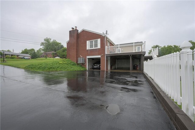 127 Burns Ave, Chippewa Twp, PA 15010 - view of side of home featuring a carport, asphalt driveway, cooling unit, a chimney, and a deck