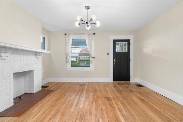 1727 Morningside Ave, Morningside, PA 15206 - foyer entrance with a chandelier, wood-type flooring, baseboards, and a brick fireplace