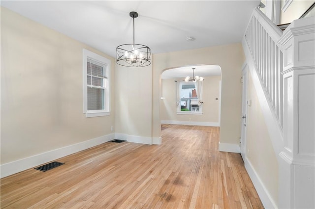 1727 Morningside Ave, Morningside, PA 15206 - spare room featuring a chandelier, arched walkways, light wood-style flooring, and baseboards