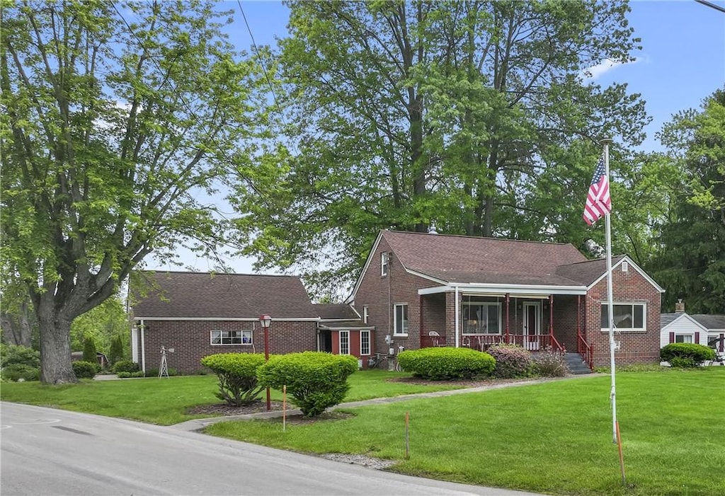 146 Samuel St, Chippewa Twp, PA 15010 - view of front of home with a porch, brick siding, and a front lawn