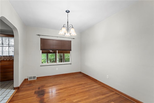 146 Samuel St, Chippewa Twp, PA 15010 - unfurnished room with arched walkways, wood finished floors, a chandelier, and baseboards