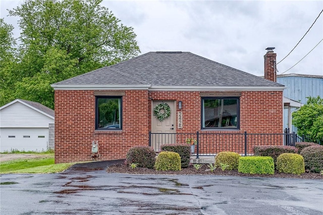 2425 W Pike St, Chartiers, PA 15342 - bungalow-style house featuring brick siding, roof with shingles, a garage, an outbuilding, and a chimney