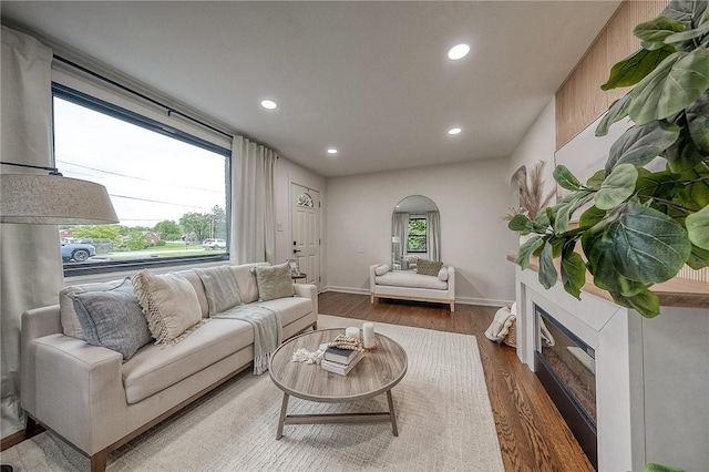 2425 W Pike St, Chartiers, PA 15342 - living area featuring wood finished floors, arched walkways, recessed lighting, a glass covered fireplace, and baseboards
