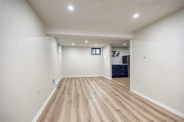 2425 W Pike St, Chartiers, PA 15342 - empty room with a baseboard heating unit, light wood-type flooring, recessed lighting, baseboards, and a textured ceiling