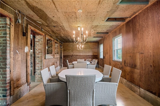 311 Derry Ridge Rd, Ligonier Twp, PA 15658 - dining room with a chandelier, wooden walls, concrete floors, and wooden ceiling