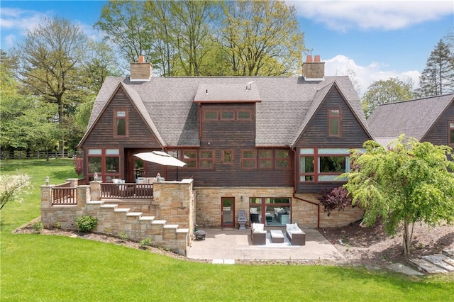 311 Derry Ridge Rd, Ligonier Twp, PA 15658 - rear view of house featuring a patio area, a chimney, a yard, stone siding, and roof with shingles