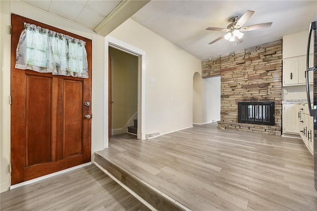 1030 N Grandview Ave, Mckeesport, PA 15132 - foyer entrance featuring a ceiling fan, light wood-type flooring, arched walkways, stairway, and a stone fireplace