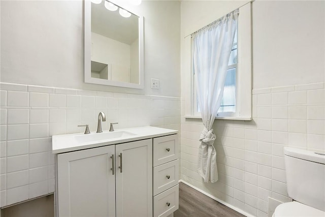 1030 N Grandview Ave, Mckeesport, PA 15132 - bathroom featuring tile walls, toilet, vanity, wood finished floors, and wainscoting