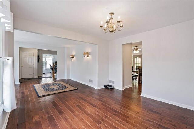 407 Pine Trees Dr, Scott Twp Sal, PA 15106 - unfurnished living room featuring a chandelier, wood finished floors, plenty of natural light, and baseboards