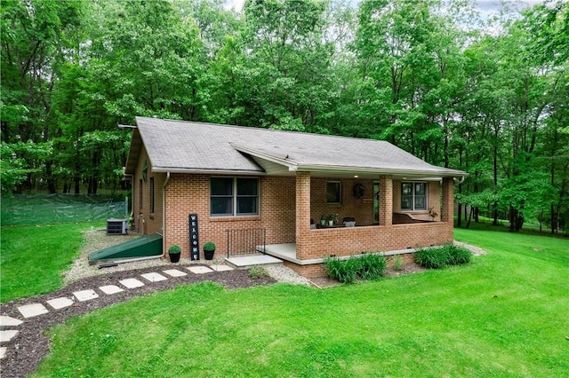 223 Cashdollar Rd, Forward Twp But, PA 16046 - view of front facade with brick siding, a front lawn, central air condition unit, and roof with shingles