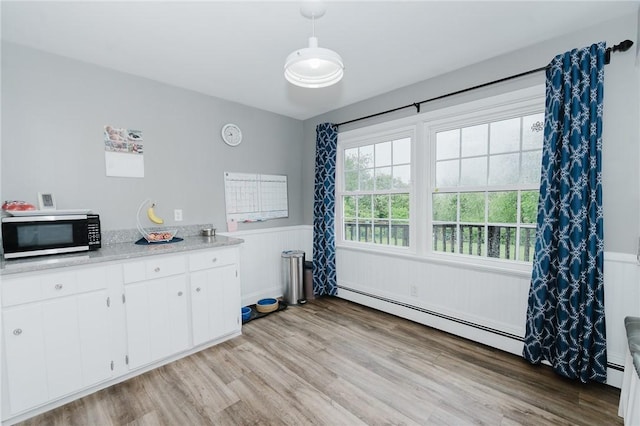3 Coates Ln, White Twp Ind, PA 15701 - kitchen with stainless steel microwave, baseboard heating, wainscoting, light wood-style flooring, and light countertops