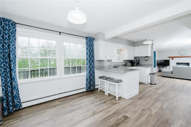 3 Coates Ln, White Twp Ind, PA 15701 - kitchen featuring white cabinets, baseboard heating, a peninsula, light countertops, and plenty of natural light