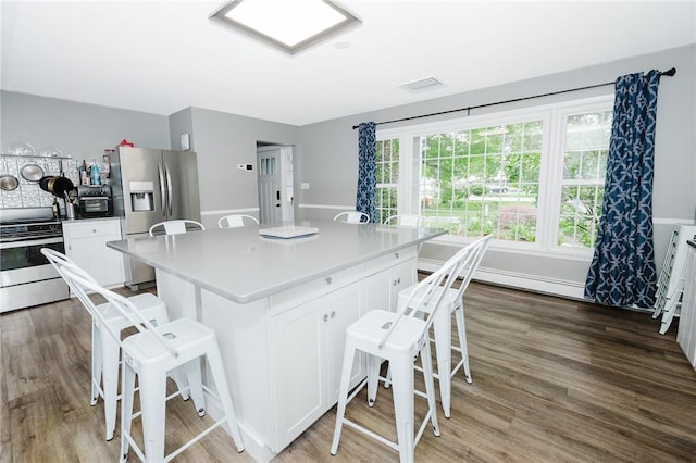 3 Coates Ln, White Twp Ind, PA 15701 - kitchen featuring appliances with stainless steel finishes, a kitchen breakfast bar, wood finished floors, white cabinetry, and a kitchen island