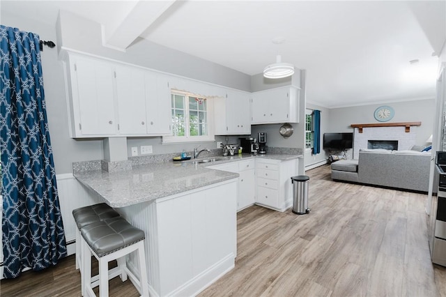 3 Coates Ln, White Twp Ind, PA 15701 - kitchen with a sink, a peninsula, white cabinetry, light wood-type flooring, and open floor plan