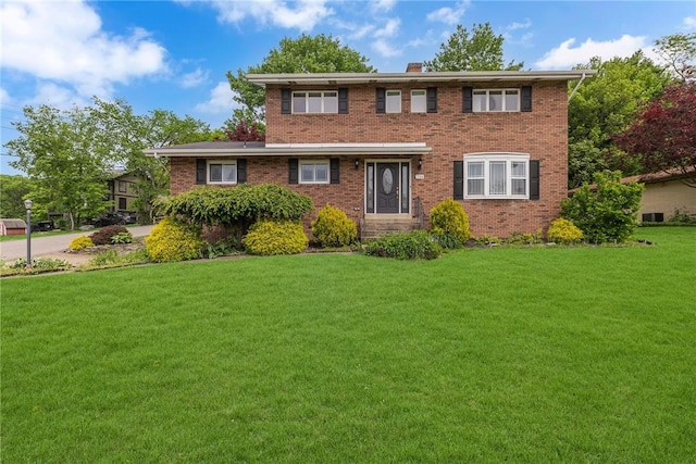 136 Upland Dr, Industry, PA 15052 - view of front facade featuring a front lawn, brick siding, and a chimney