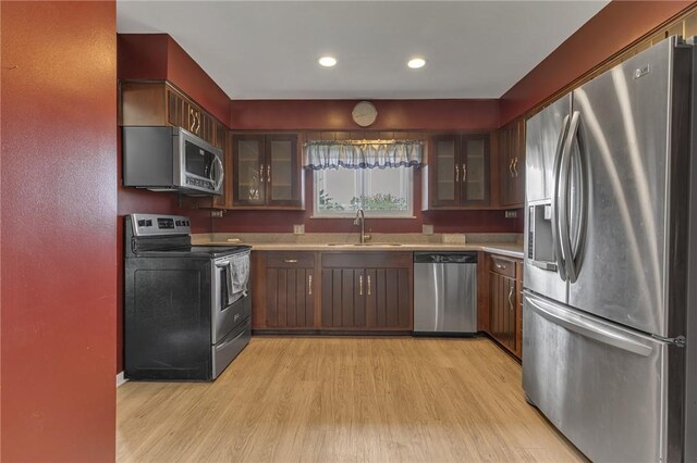 136 Upland Dr, Industry, PA 15052 - kitchen featuring appliances with stainless steel finishes, a sink, light countertops, light wood-type flooring, and glass insert cabinets