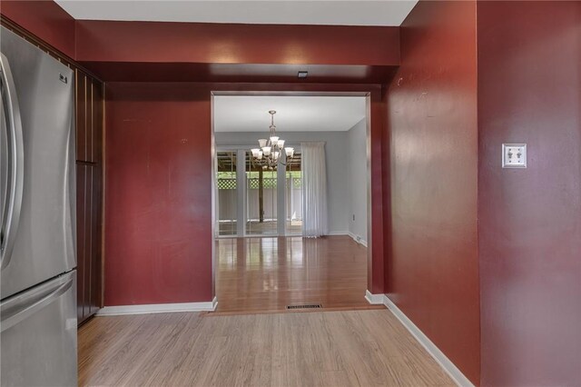 136 Upland Dr, Industry, PA 15052 - unfurnished dining area featuring light wood-style floors, a chandelier, and baseboards