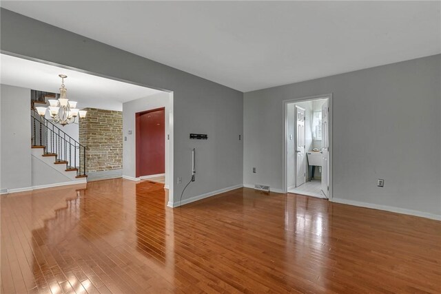 136 Upland Dr, Industry, PA 15052 - unfurnished room with a chandelier, wood finished floors, baseboards, and stairway