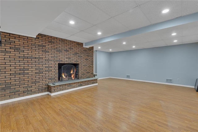 136 Upland Dr, Industry, PA 15052 - unfurnished living room with wood finished floors, a drop ceiling, a fireplace, baseboards, and recessed lighting