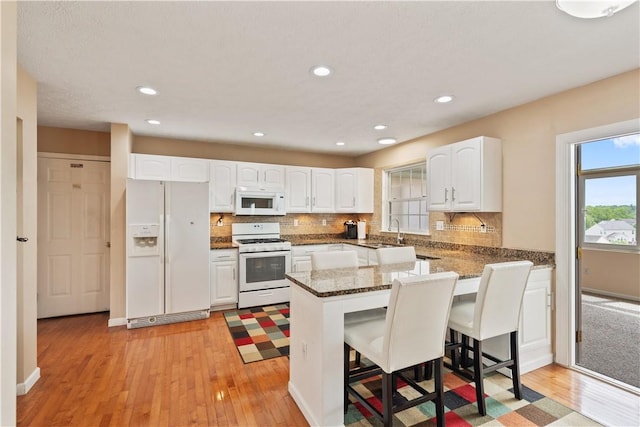 5109 Forest Ridge Dr, South Fayette, PA 15057 - kitchen featuring white appliances, a peninsula, light wood-style flooring, white cabinets, and recessed lighting