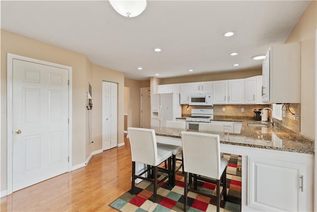 5109 Forest Ridge Dr, South Fayette, PA 15057 - kitchen featuring white appliances, a sink, a peninsula, white cabinets, and stone counters
