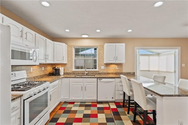 5109 Forest Ridge Dr, South Fayette, PA 15057 - kitchen featuring white appliances, a sink, tasteful backsplash, a breakfast bar area, and recessed lighting