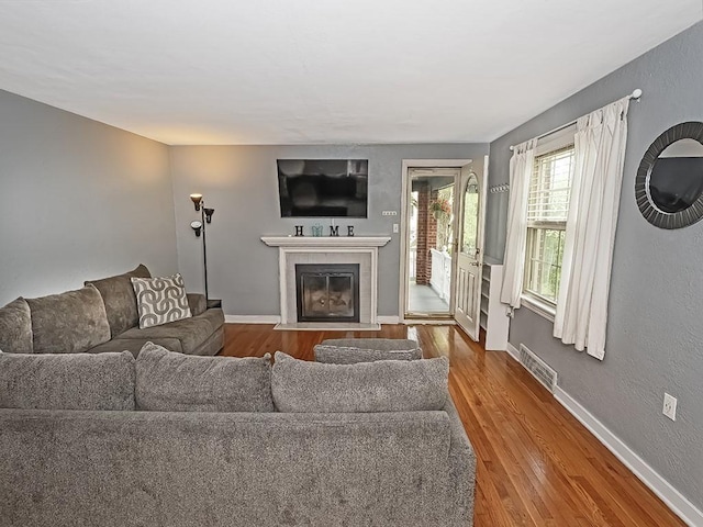 1188 Logan Rd, Bethel Park, PA 15102 - living room featuring wood finished floors, a fireplace with flush hearth, and baseboards